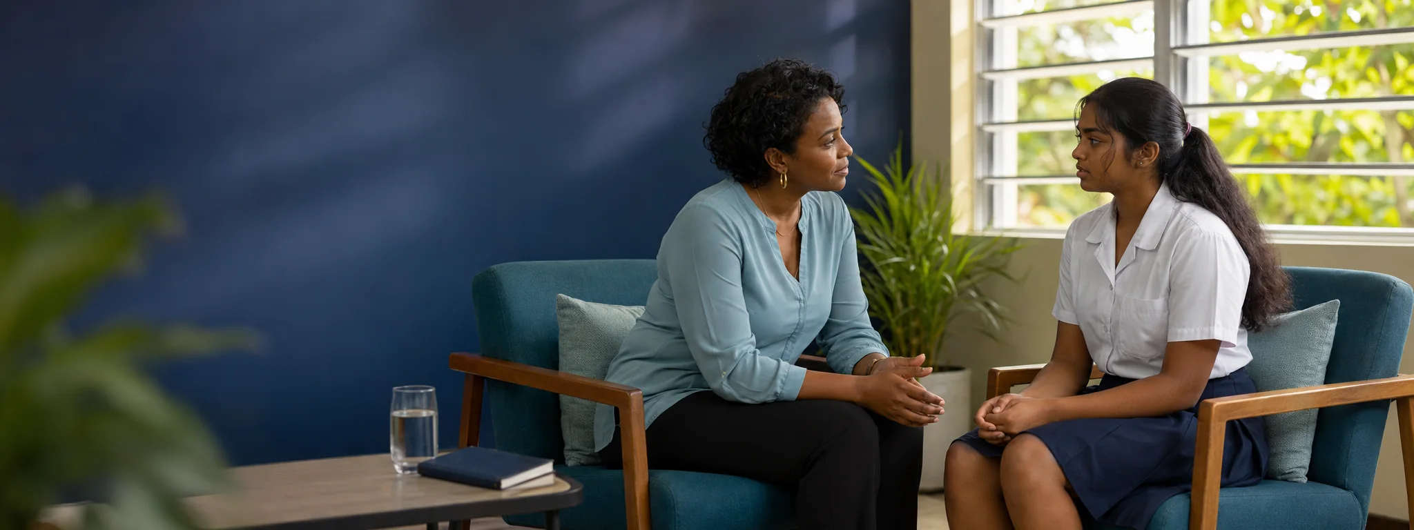A trusted Caribbean educator listening privately and supportively to a secondary-school student